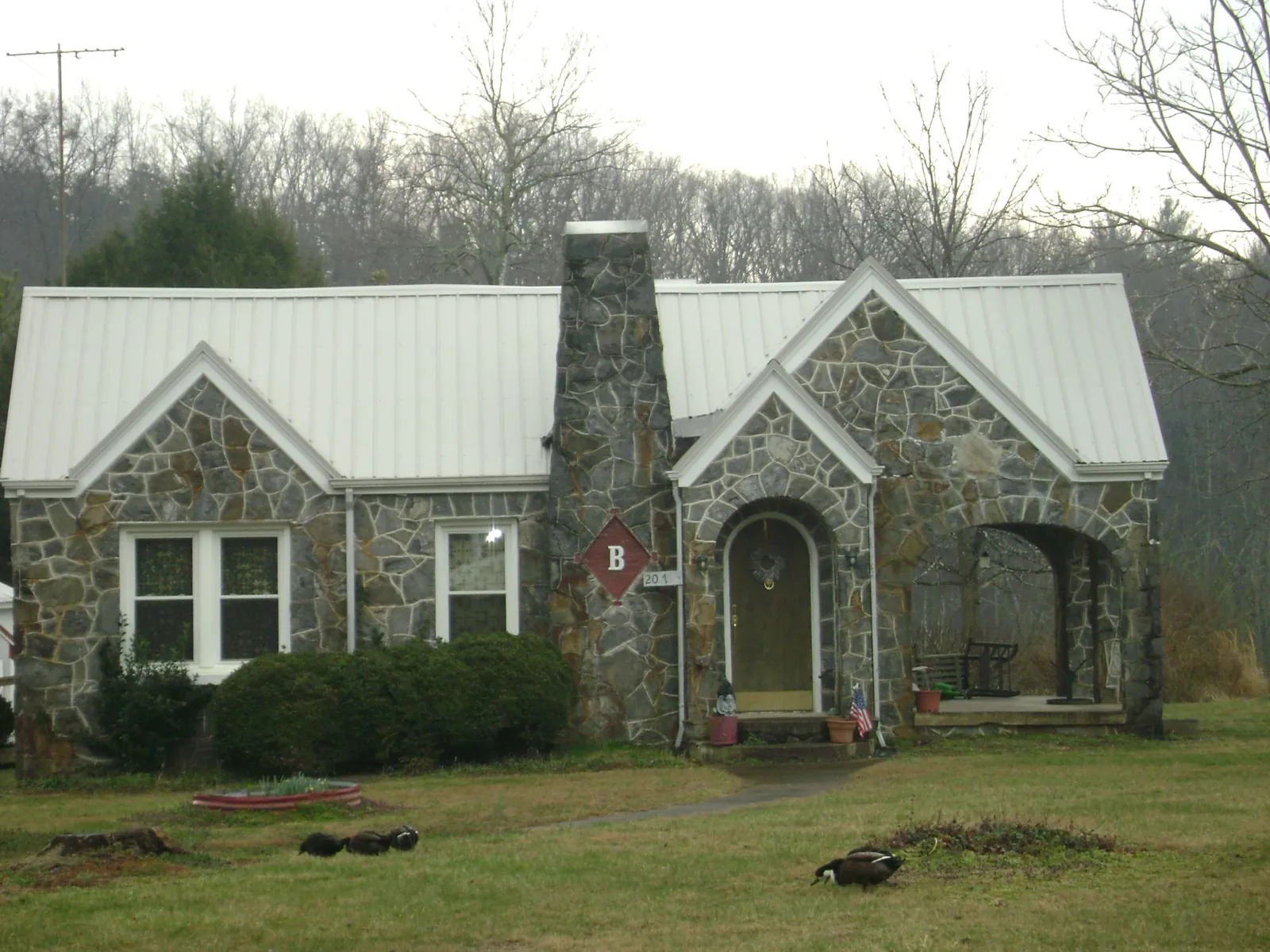 White metal roof on a stone cottage with steep gables in Lummi Island